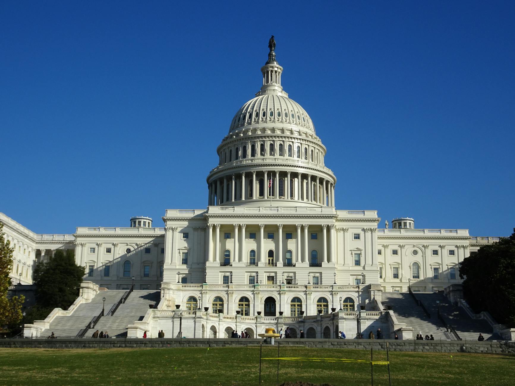 Stunning facade of the iconic United States Capitol in Washington D.C. against a clear blue sky.