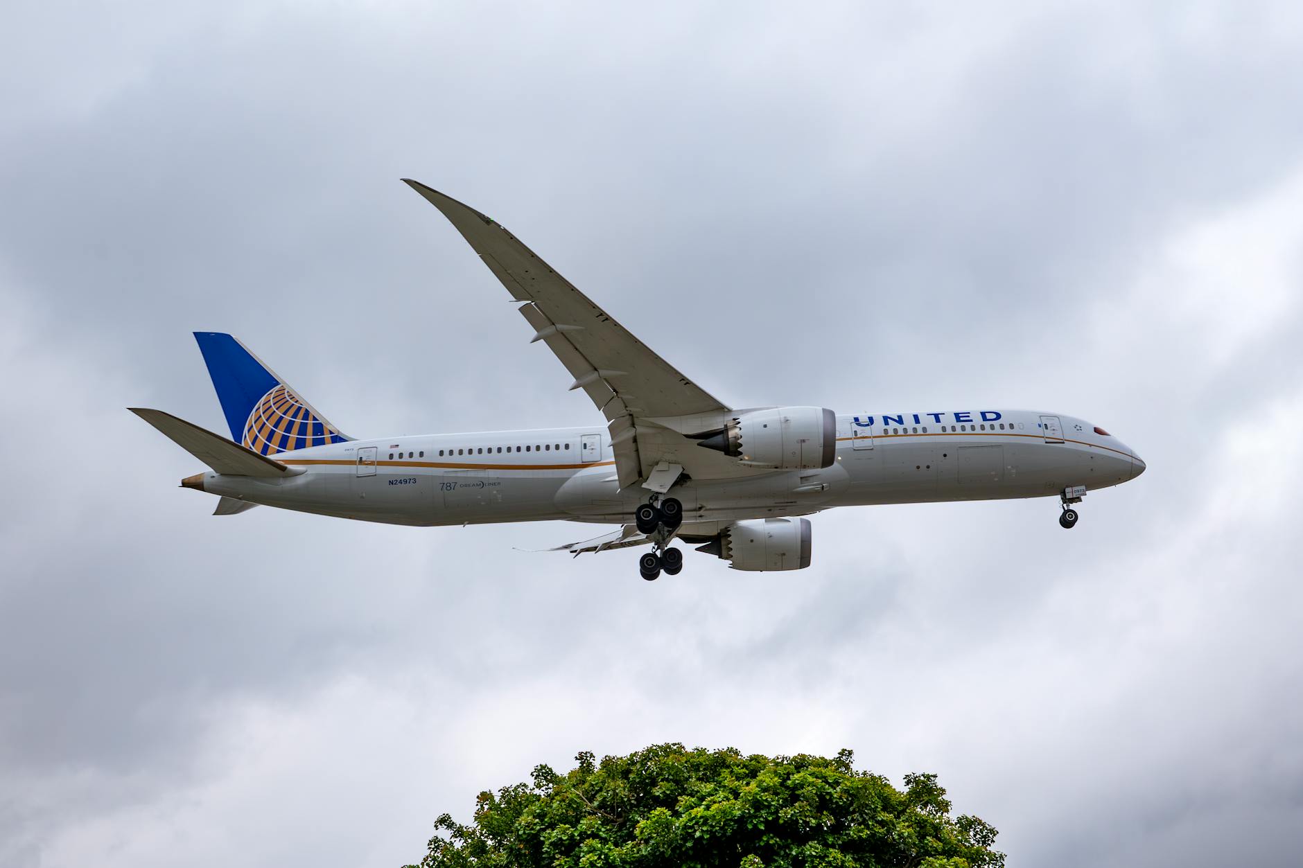 United Airlines Boeing 787 flies over Los Angeles sky, preparing for landing at LAX.