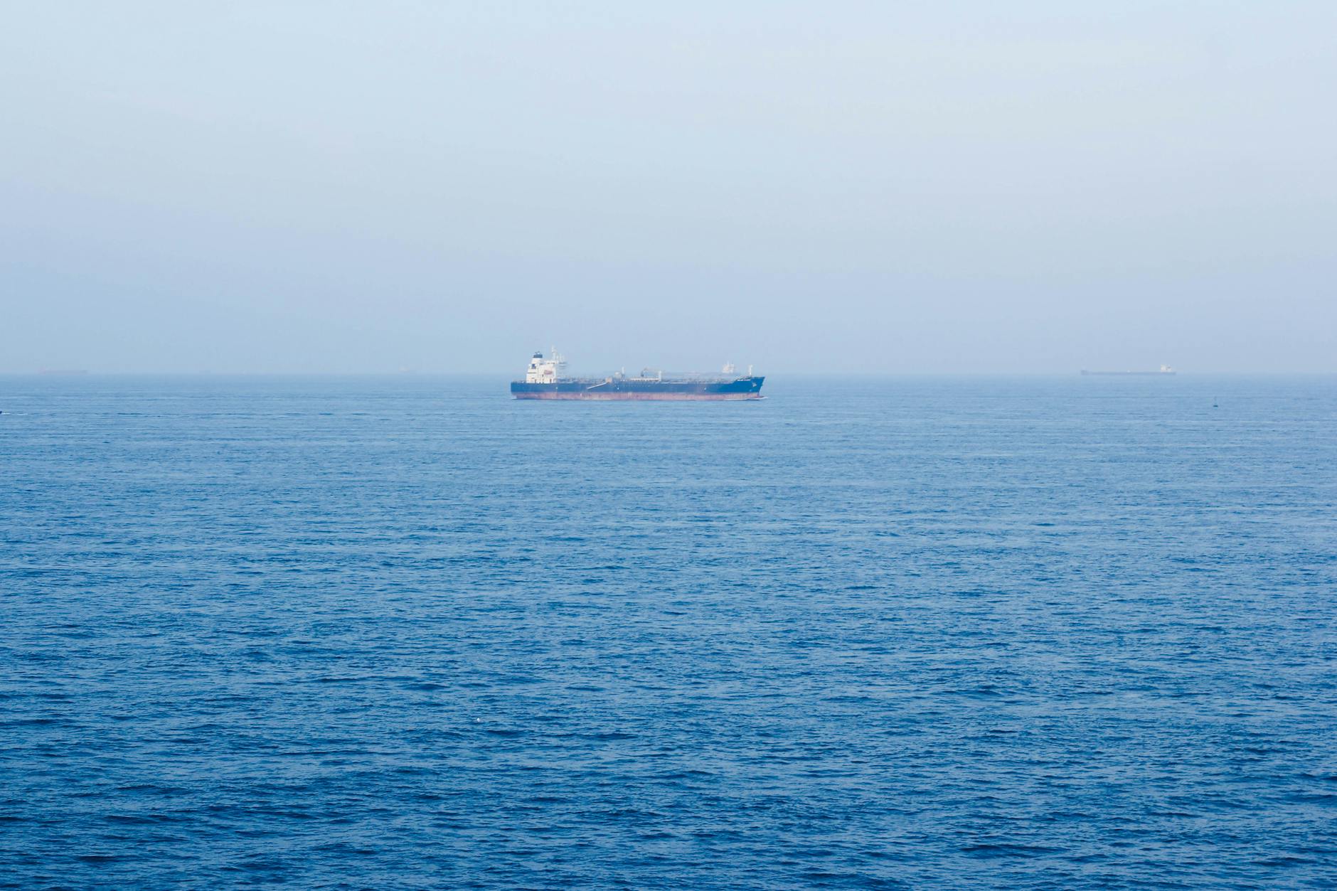 A large cargo ship sails on the tranquil ocean near Vũng Tàu, Vietnam, symbolizing global commerce.