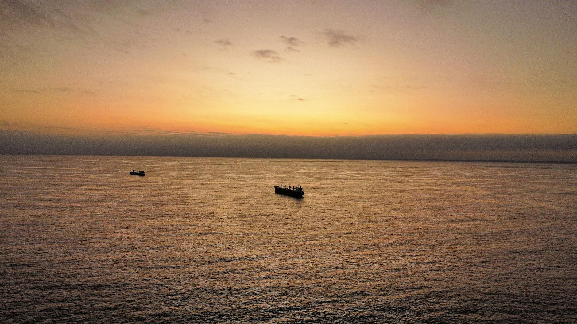 Aerial view of ships sailing on the Pacific Ocean during a beautiful sunset near Antofagasta, Chile.