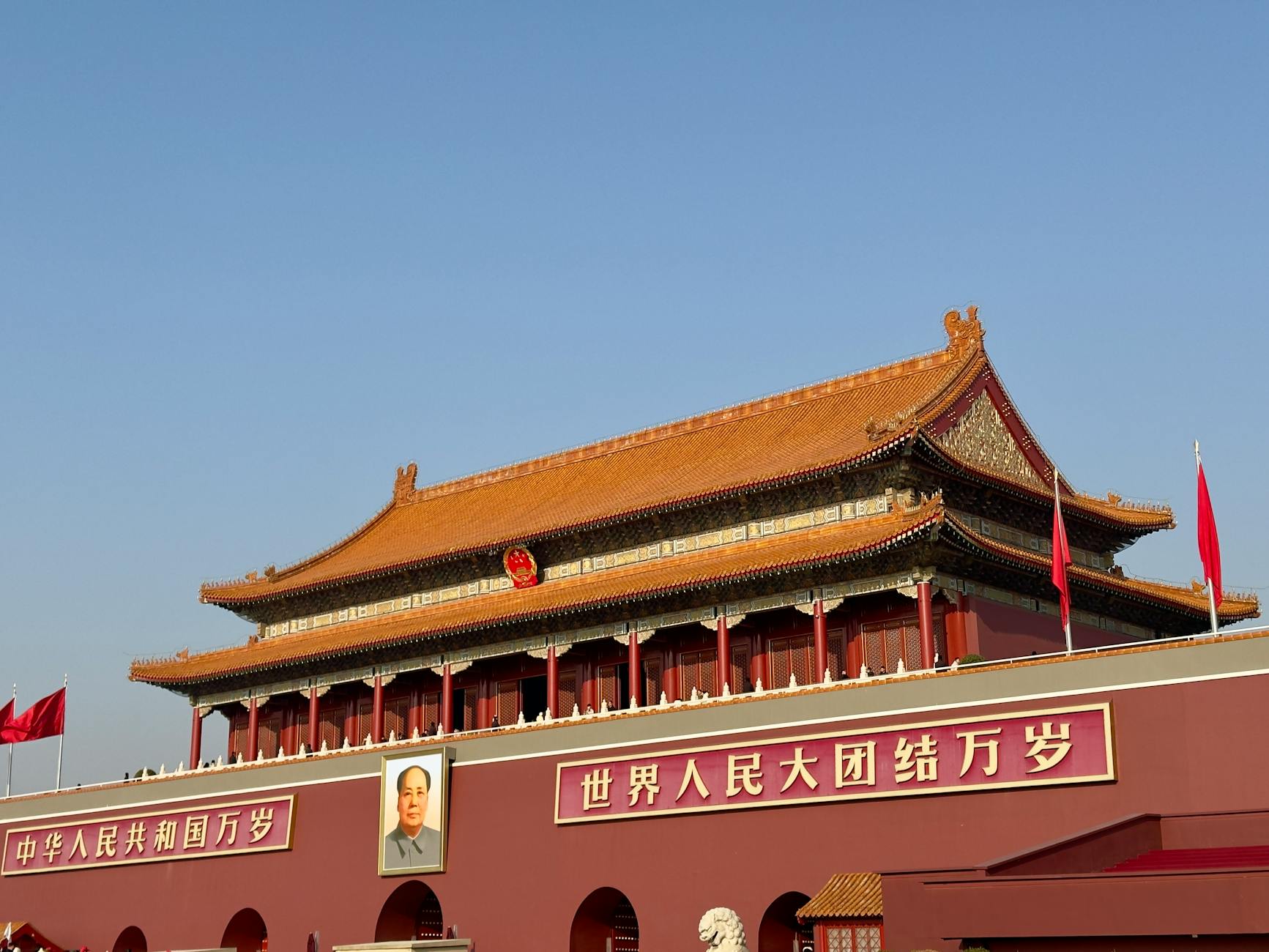 Historic Tiananmen Gate under blue skies in Beijing, China, symbolic and tourist landmark.