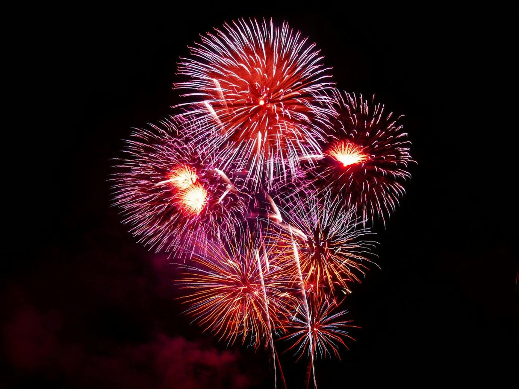 Colorful fireworks burst against a dark night sky, perfect for New Year or Independence celebrations.