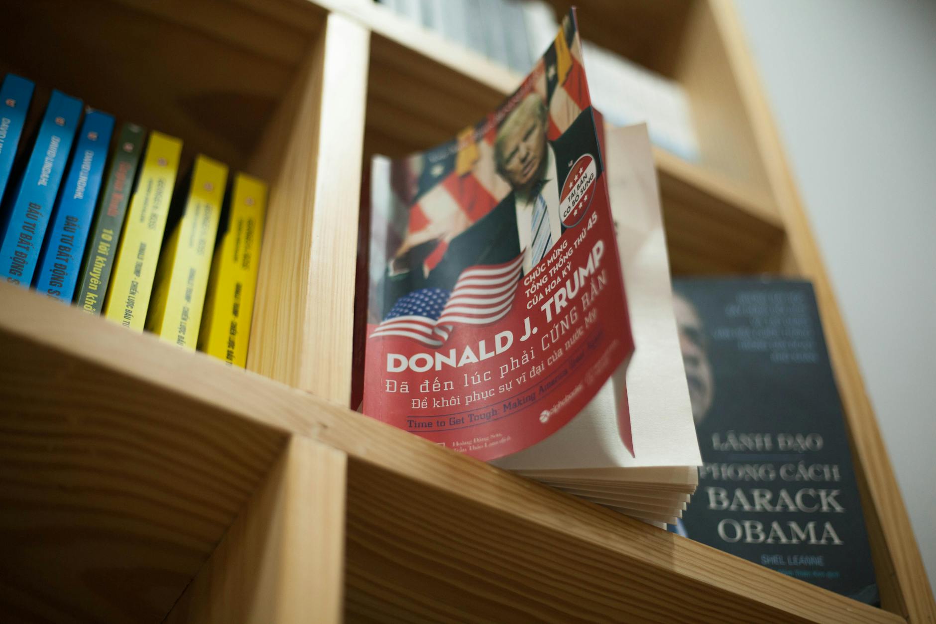 A close-up view of a bookshelf with books featuring political leaders in a bookstore setting.