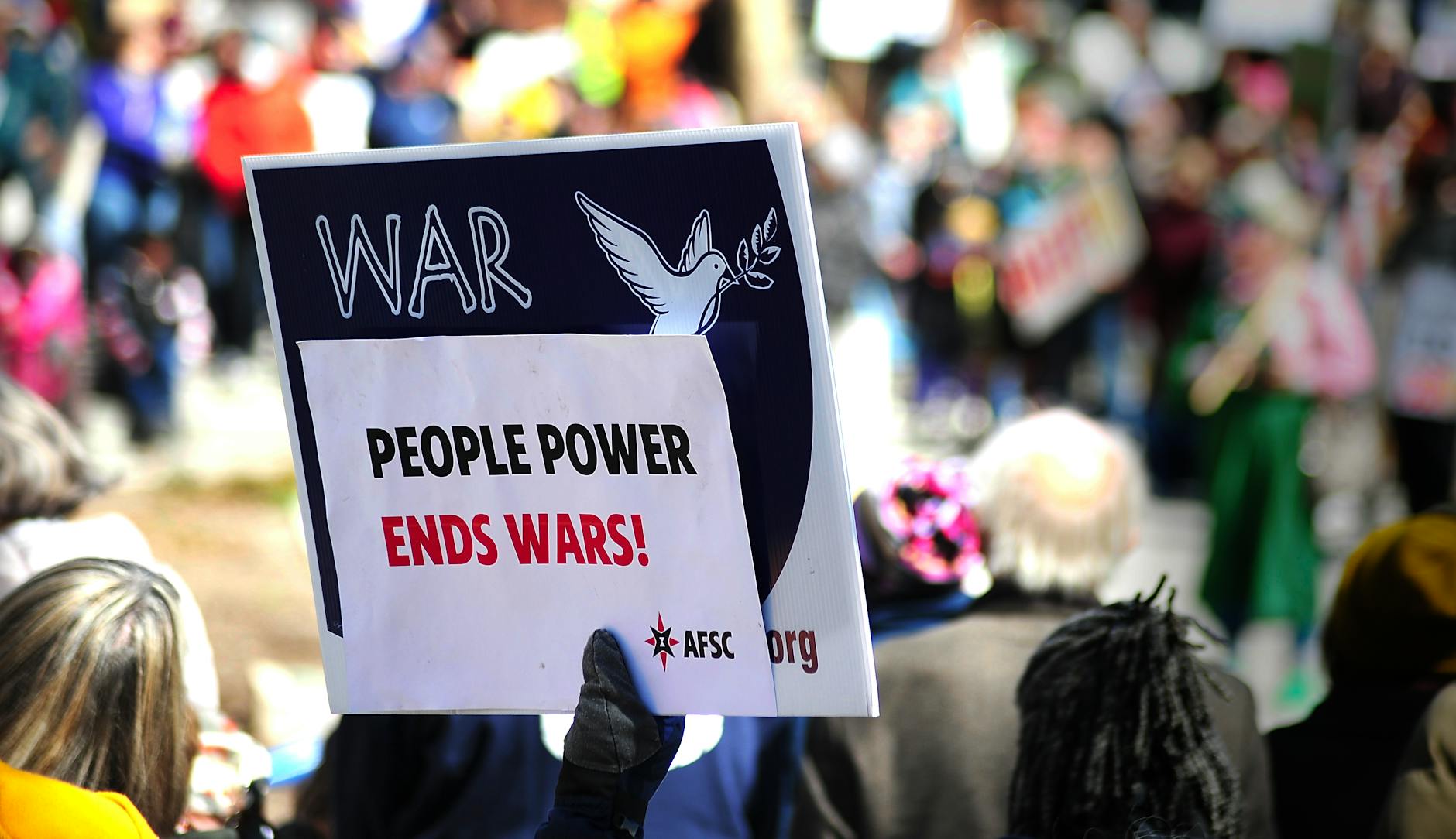 Protest sign reading 'People Power Ends Wars!' at a rally in Baltimore.