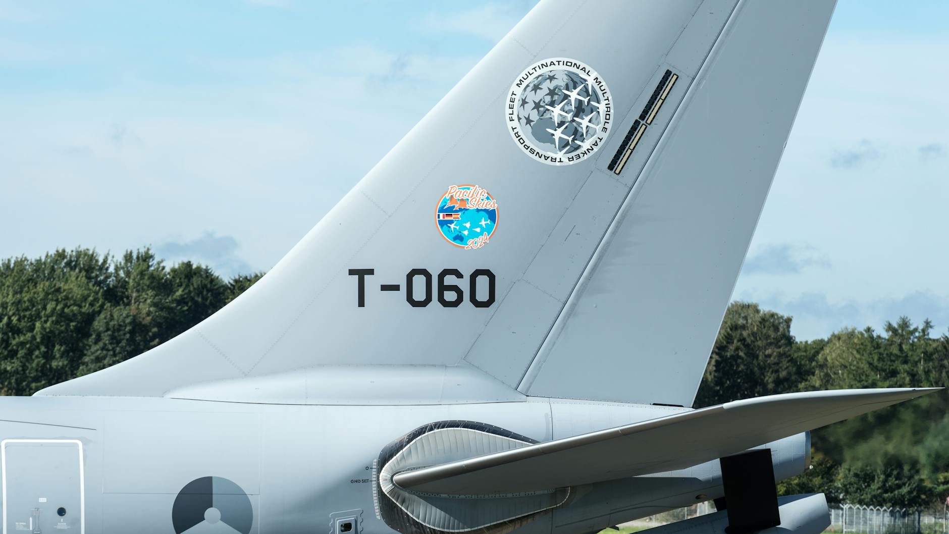 Detailed view of airplane tail with insignia at Hamburg Airport on a clear day.