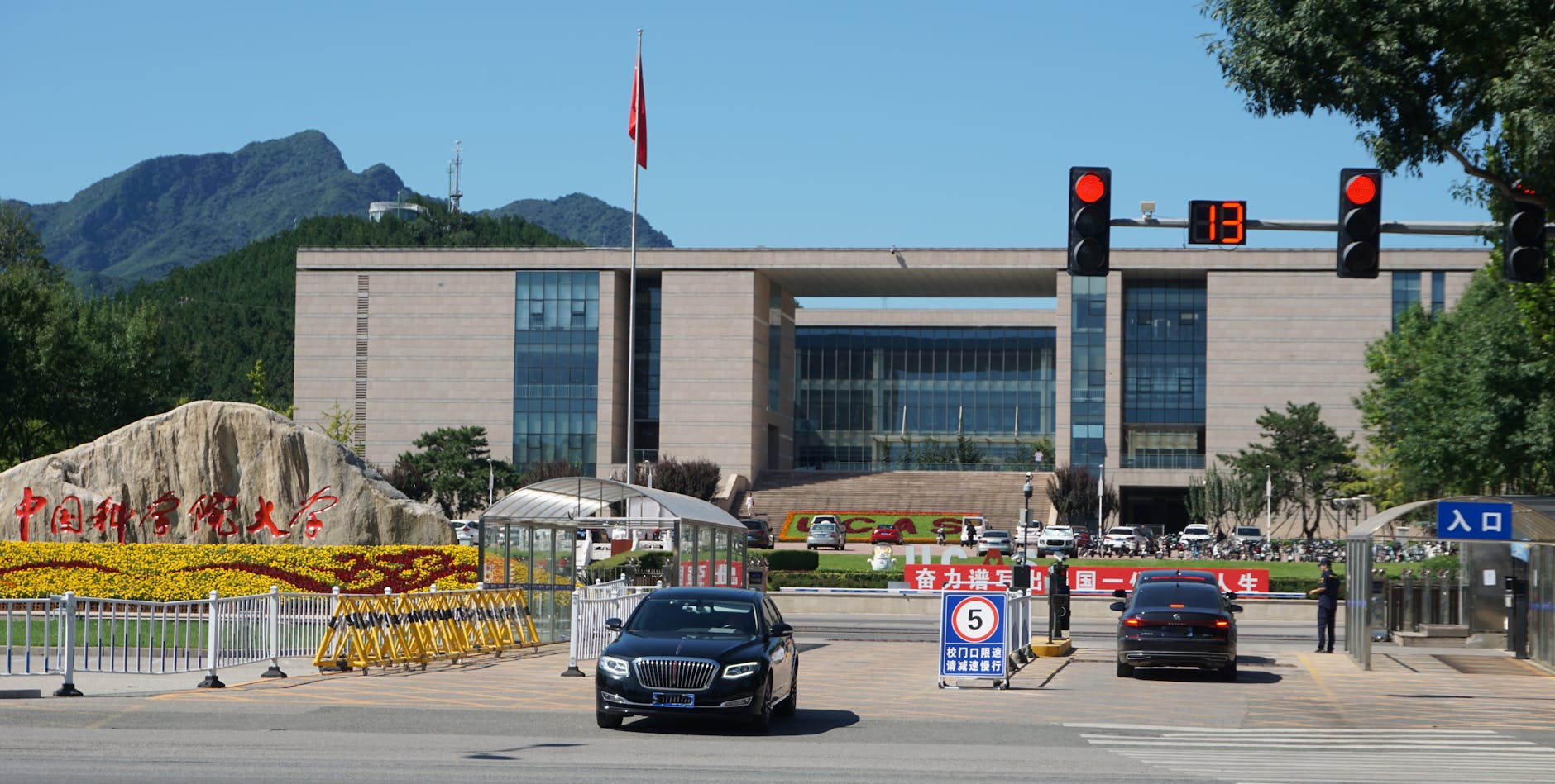 Main entrance of China Agricultural University with building and mountains in the background.