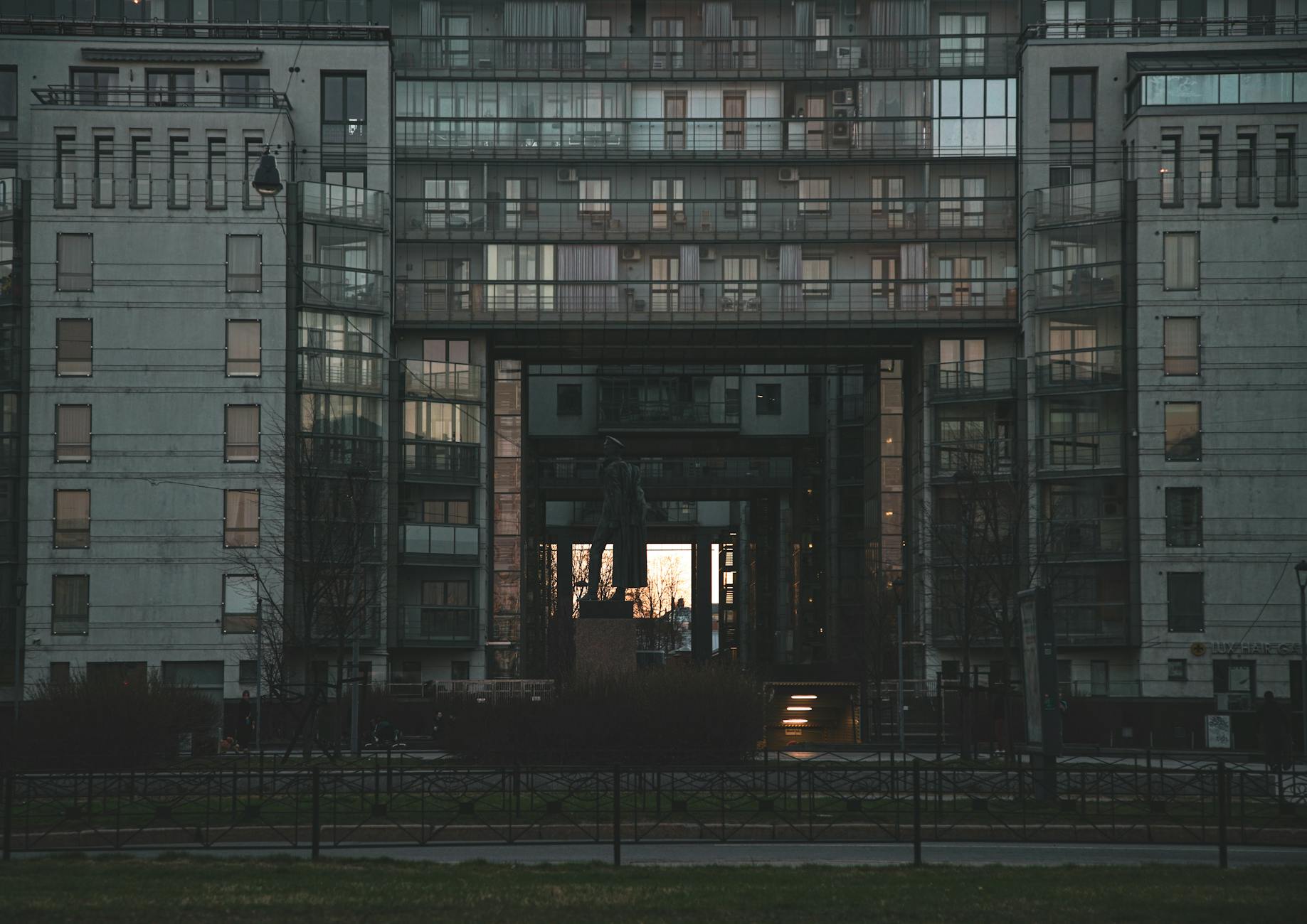 A striking modern apartment building in St. Petersburg under a twilight sky, showcasing a unique facade.