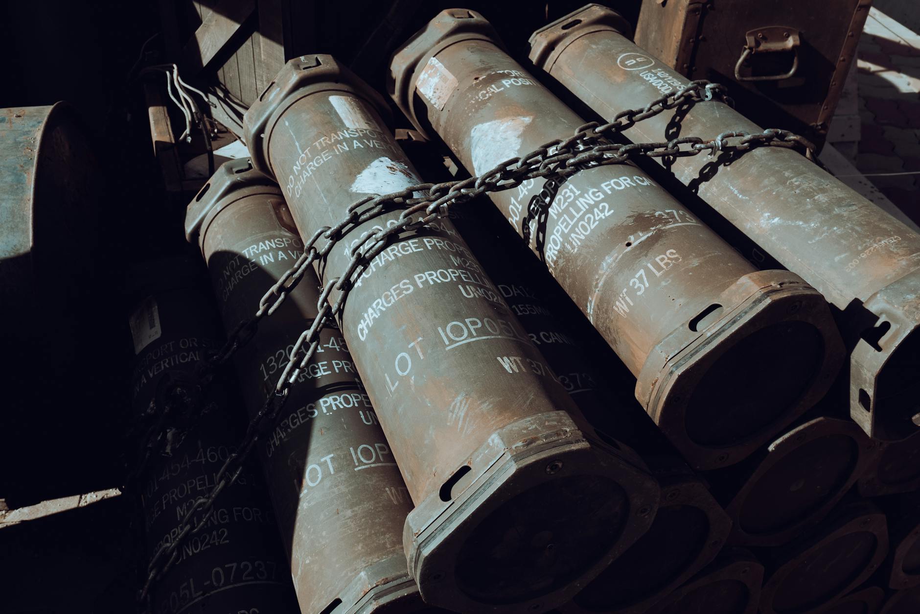 Close-up of chained military missile containers in a warehouse.
