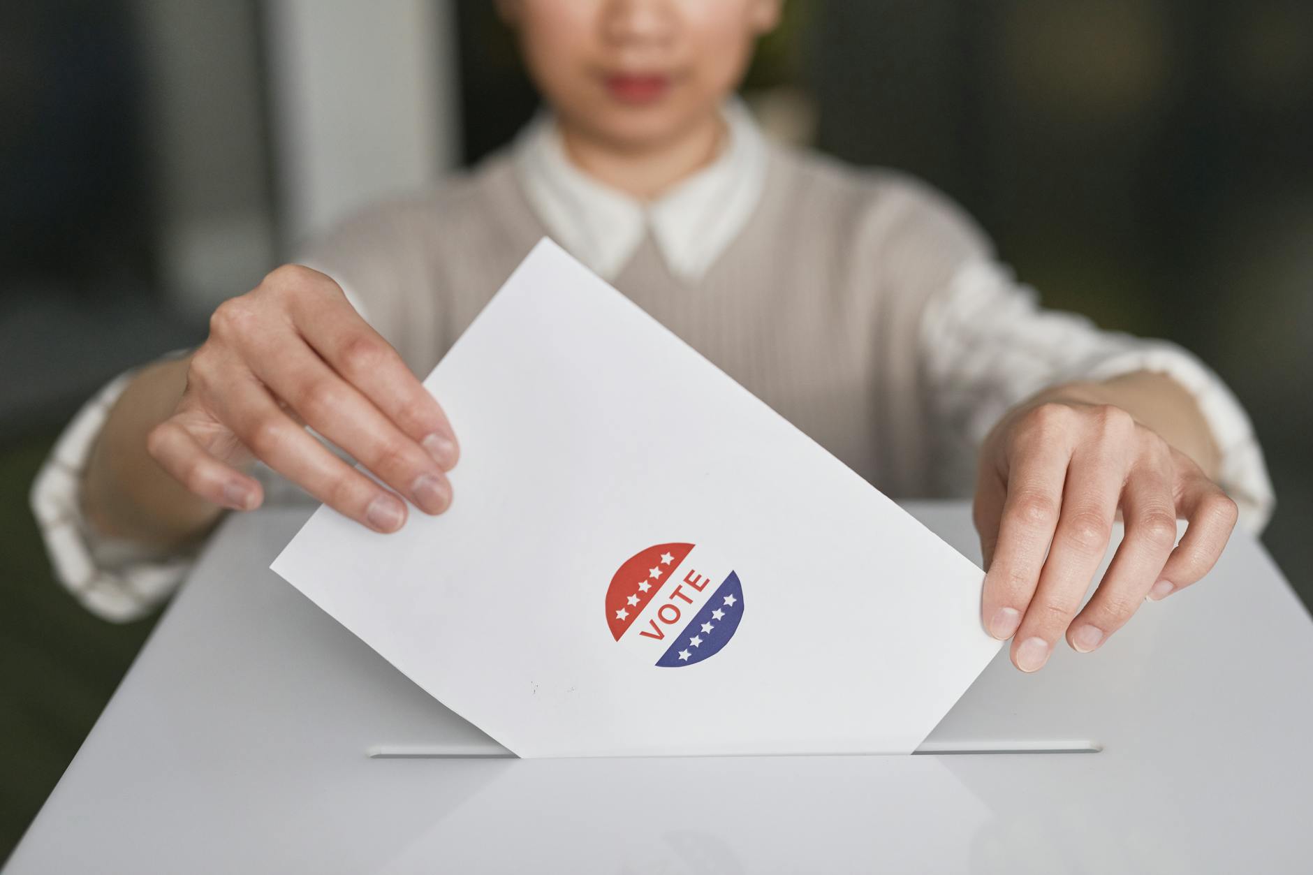 Congress Orders satire image: A person casting a vote by placing a ballot into a ballot box, symbolizing democratic participation.