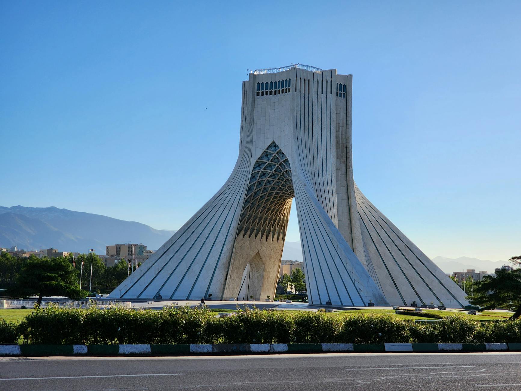A stunning view of the Azadi Tower in Tehran, Iran, showcasing its unique architecture against a clear blue sky.