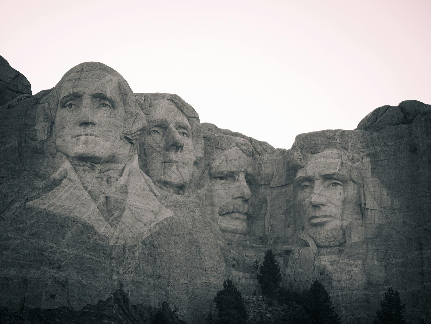 Iconic black and white view of Mount Rushmore, showcasing historical presidential carvings.