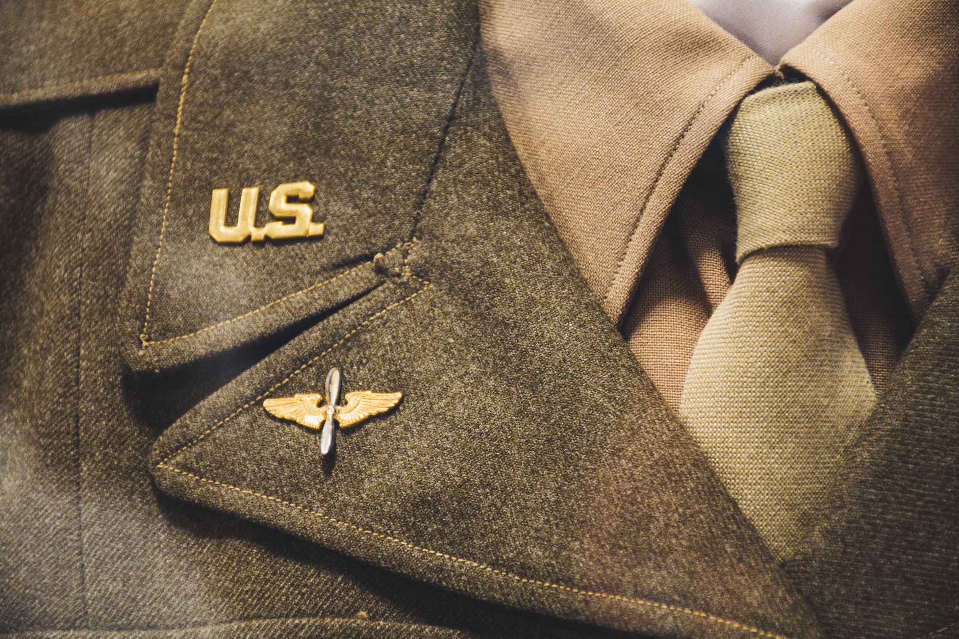 Congress Requires satire image: Close-up of a vintage U.S. military uniform featuring badge and tie, representing historical military