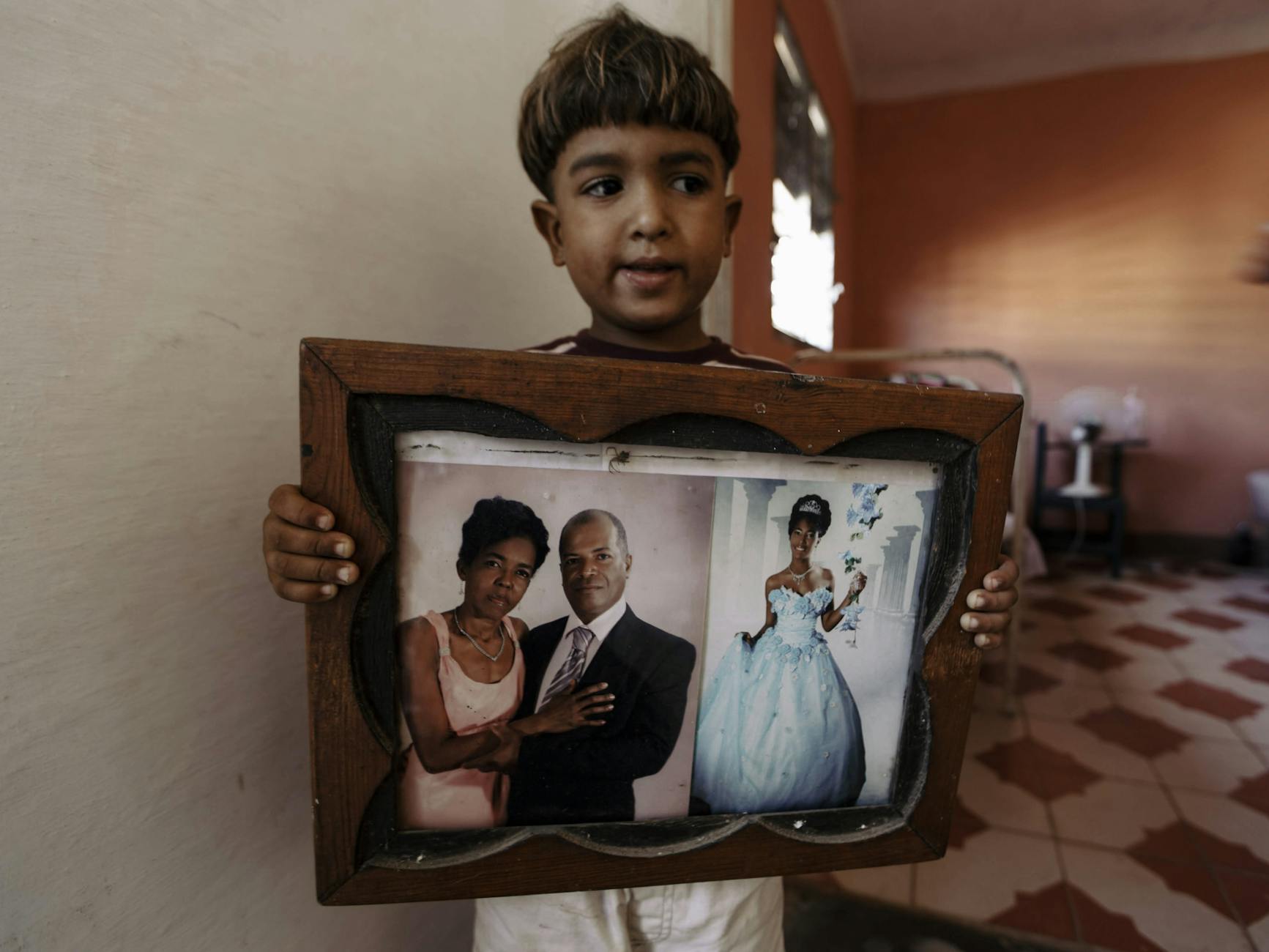 White House Sanctions satire image: A young boy holds a framed family portrait, depicting touching family memories.