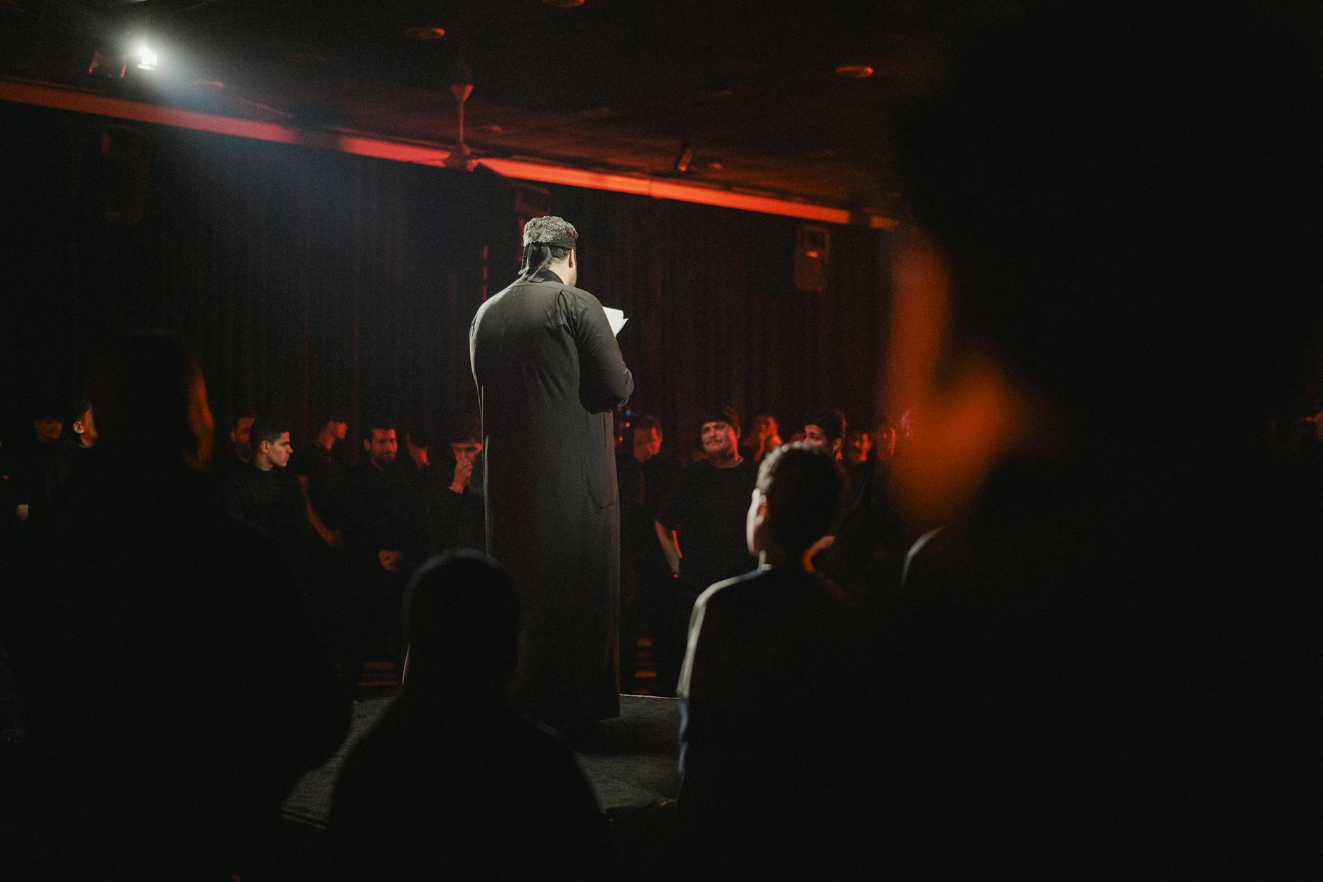 Congress Senate satire image: A speaker addresses an attentive audience in a dimly lit room, creating an intimate atmosphere.