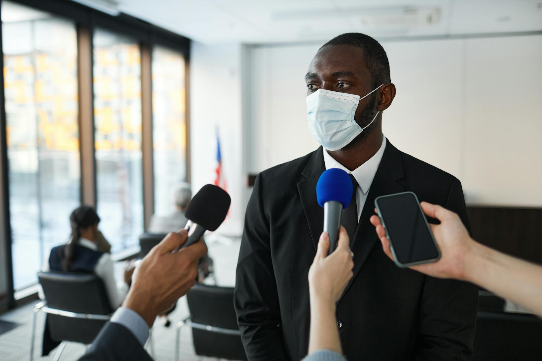 satire-image-37 Trump Senate satire image: African American businessman in formal attire speaks to media while wearing a face mask in a conference room