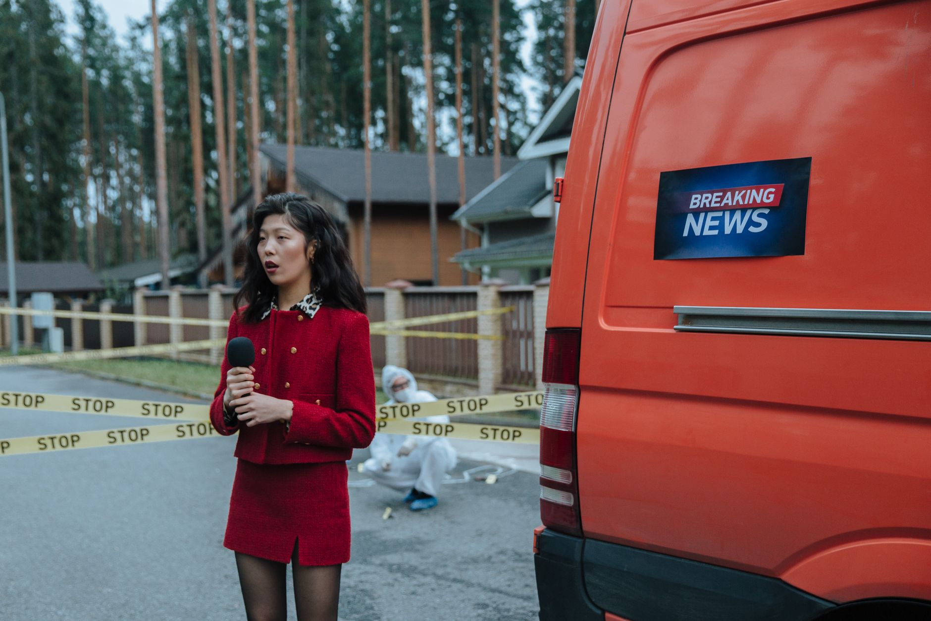 satire-image-43 China Fbi satire image: Female reporter in red outfit at an outdoor crime scene with warning tape and a news van.