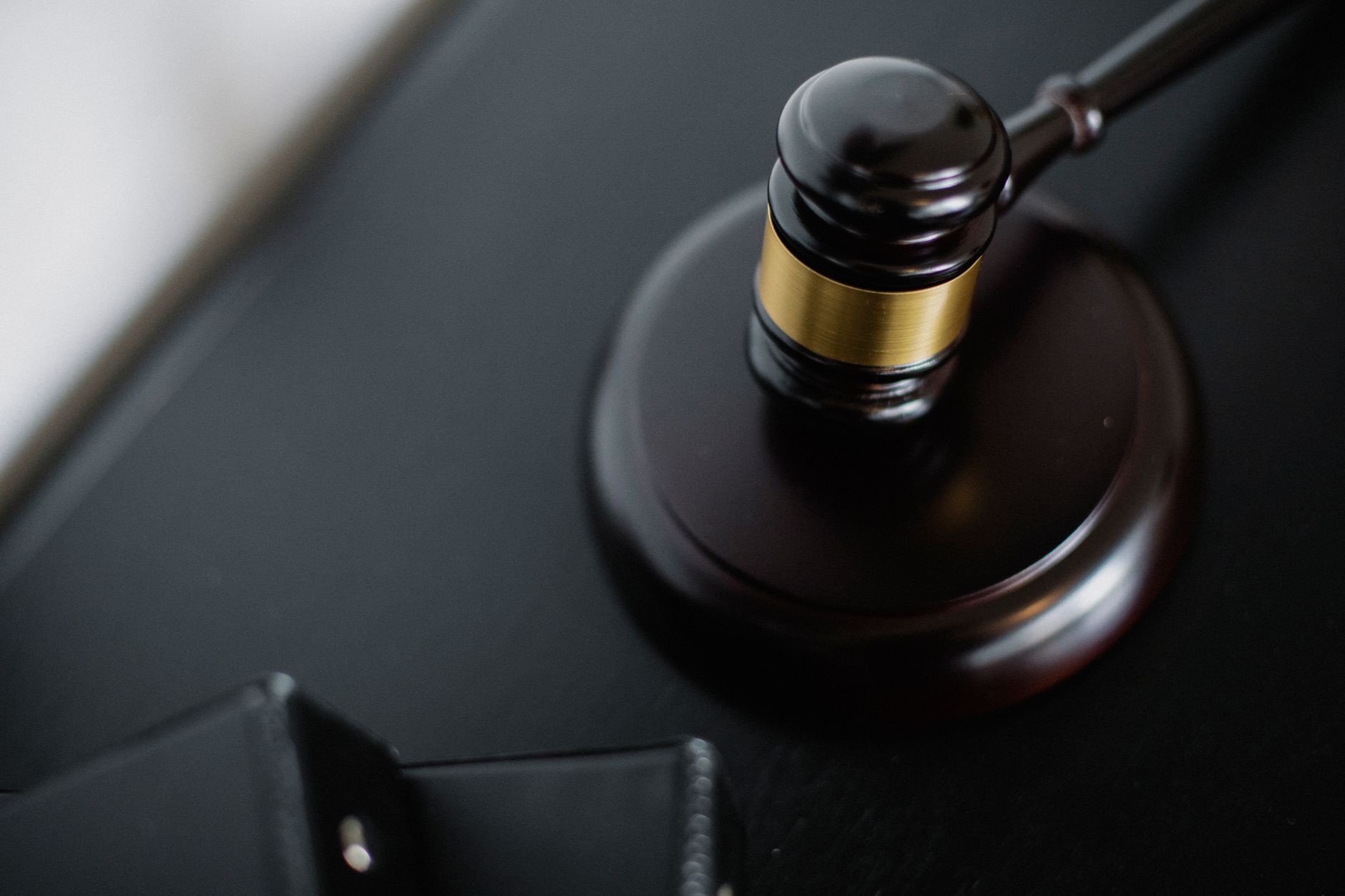 satire-image-46 Supreme Court Canada satire image: From above of wooden gavel on round surface near folders on table in courtroom