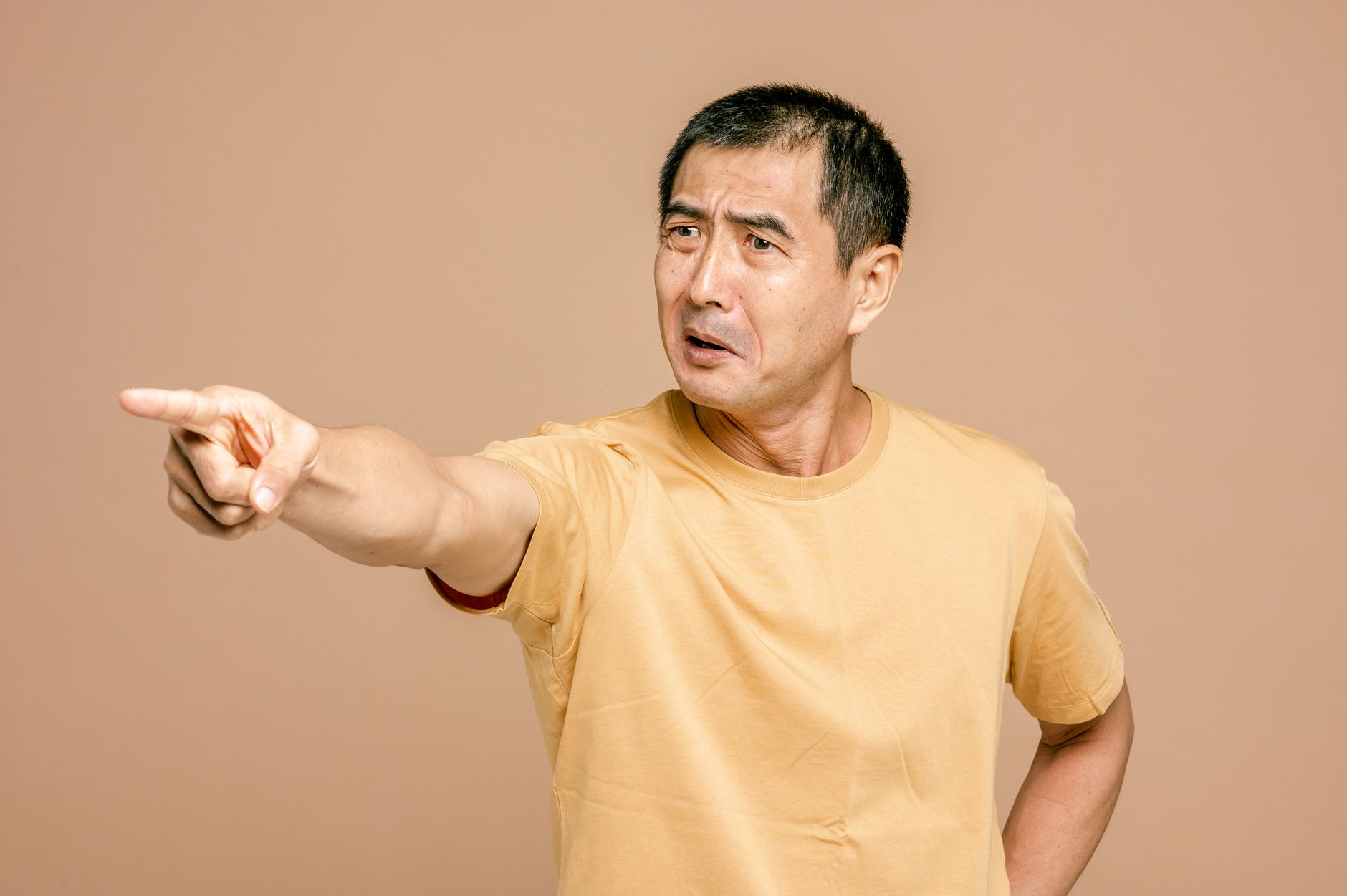 satire-image-52 China Beijing satire image: Senior Asian man expressing anger and pointing on a brown background.