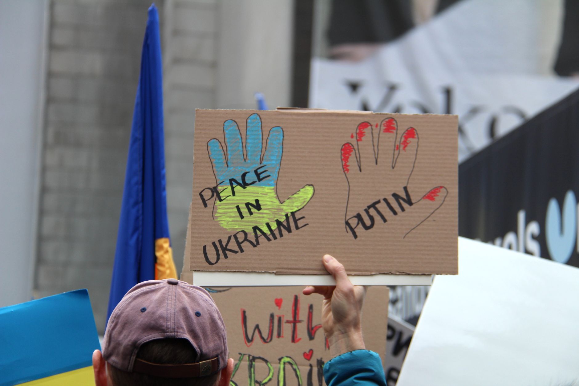 Trump Installs satire image: Crowd in Vancouver holding signs calling for peace in Ukraine during a protest.