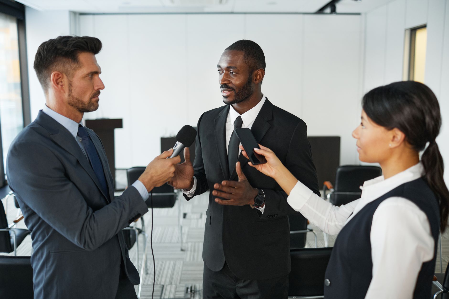 satire-image-58 Trump Files satire image: African American businessman in formal attire being interviewed by journalists with microphones in a conference
