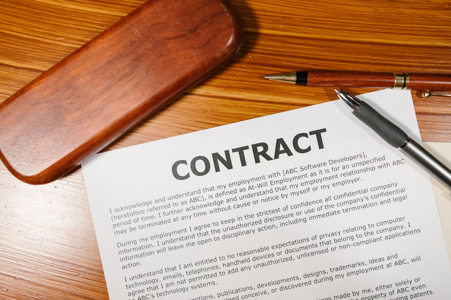 satire-image-68 Trump Releases satire image: A close-up view of a contract and pen on a wooden desk, ideal for business themes.