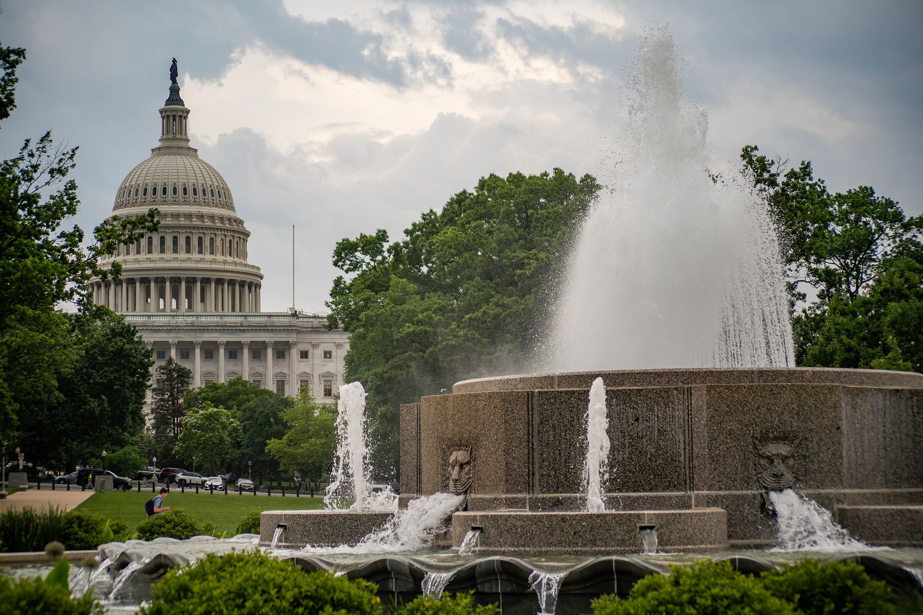 satire-image-72 Trump Asks satire image: A scenic view of the US Capitol building with a fountain in the forefront, surrounded by lush greenery.