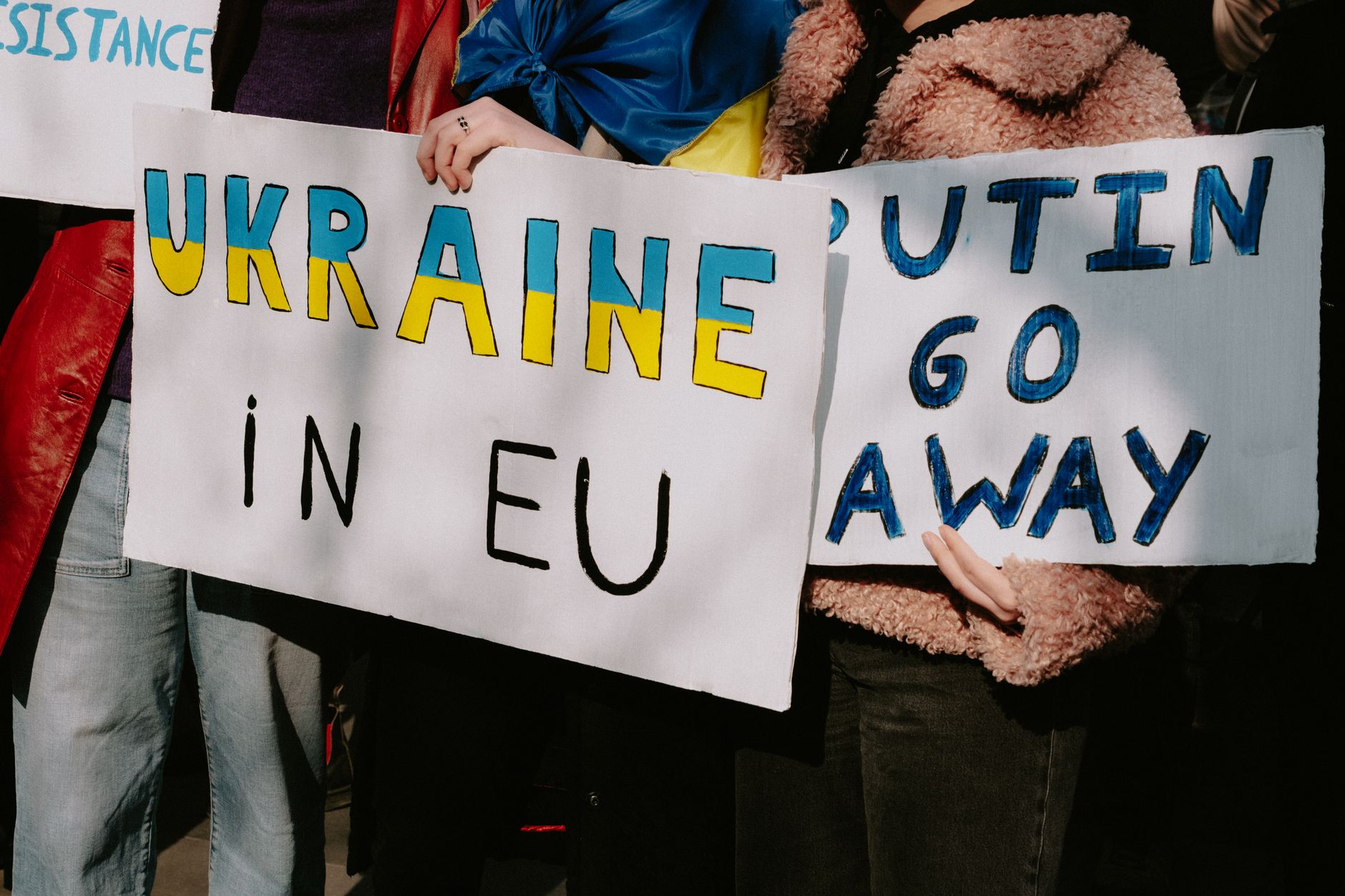 satire-image-75 Trump Unveils satire image: Protest with signs supporting Ukraine in EU and opposing Putin. Capturing a social movement outdoors.