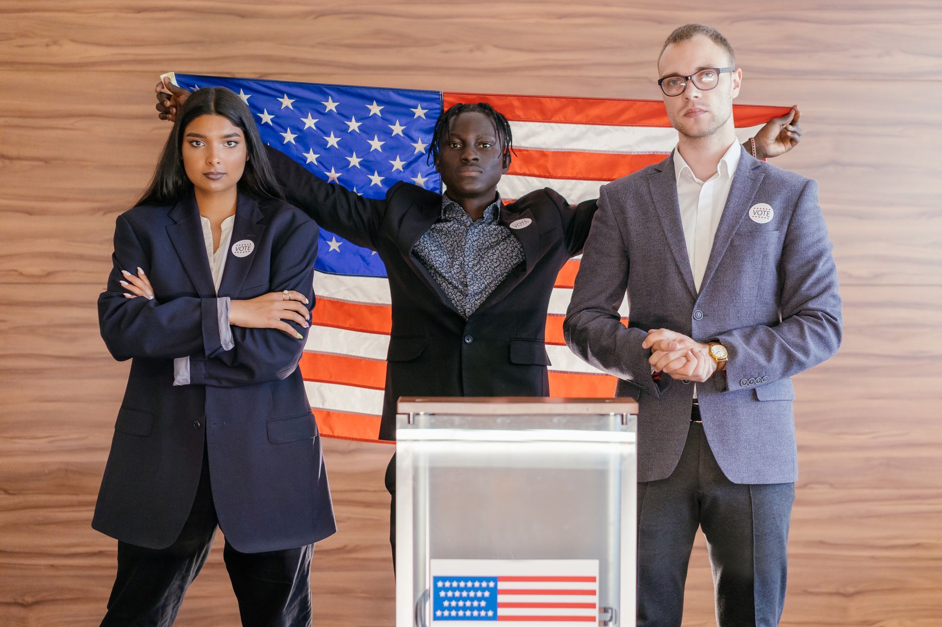 satire-image-78 Trump Endorses satire image: A group of diverse individuals standing confidently in front of an American flag at an election podium.
