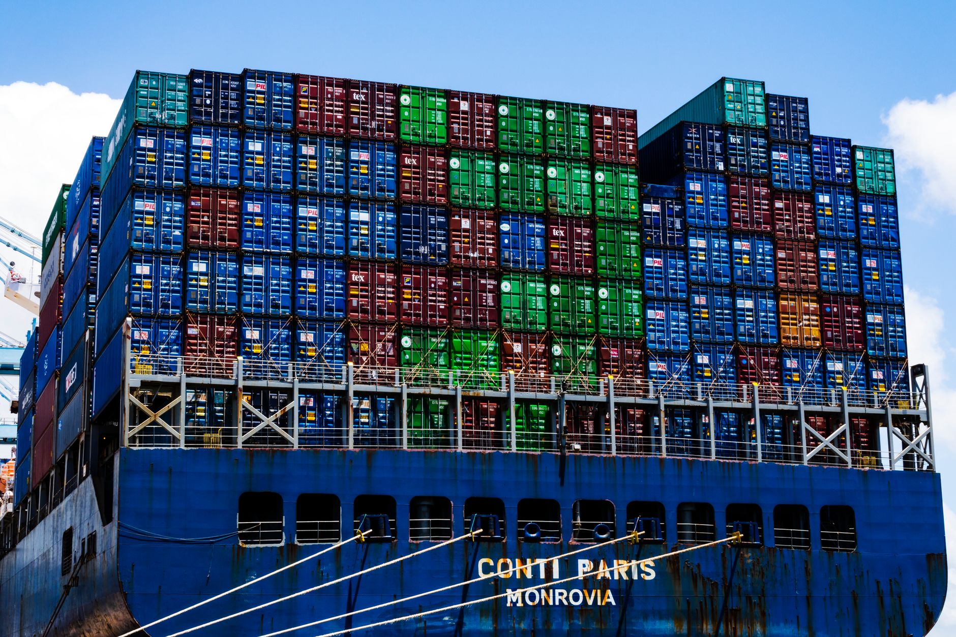 Tariff Treasury satire image: Stacked cargo containers on a massive ship at the harbor, symbolizing global trade.